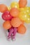 Little girl covered in colorful balloons