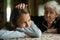 A little girl cries and her grandmother soothes stroking his hand on the head