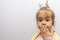 A little girl in a crown demonstrates toy rings on her fingers, children`s jewelry and bijouterie.