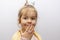 A little girl in a crown demonstrates toy rings on her fingers, children`s jewelry and bijouterie.