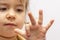 A little girl in a crown demonstrates toy rings on her fingers, children`s jewelry and bijouterie.