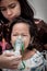 Little girl crying while getting in inhaler mask in hospital