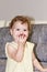 Little girl with curly hair eats an apple. Portrait of a child with an apple, eternal hazel eyes