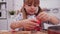 Little girl cutting christmas cookies from a gingerbread dough