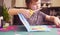 Little girl cutting colored paper with scissors