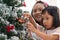 Little girl decorate christmas tree with ornament