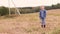 Little girl in a denim suit stands in the field and looks at the camera