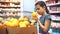 Little girl with digital tablet at the grocery store buys oranges fruit online. little girl in the hypermarket lifestyle