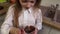 Little girl with dirty face eating chocolate pudding