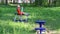 Little girl does exercises on outdoor exerciser in green park