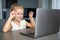 Little girl does finger gymnastics online on the laptop home. Distance learning concept.
