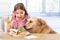 Little girl and dog having breakfast together