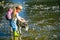 Little girl with dog walking in the river. Children and dog exploring. Children tourists and dog in beautiful nature.