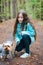 Little girl with dog walking on the road in forest