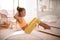 Little girl doing yoga exercise at home on board