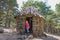 Little girl in the door frame of ancient hut in forest of Madrid mountain