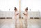 Little girl with down syndrome at ballet class in dance studio, standing in front of mirror. Concept of integration and