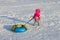 Little girl drags bright snowtube on snow