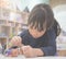 Little girl is drawing on a plaster doll in classroom