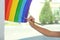 Little girl drawing rainbow on window, closeup. Stay at home concept