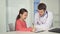 Little girl draws on clipboard near the doctor