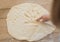 Little girl draws a smiley on a dough on a table