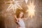 little girl dreamily touches decorative luminous stars, dressed as a ballerina with loose hair, against the backdrop of a loft