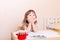 Little girl dreaming sitting at the table in preschool