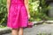 Little girl in dress child hand holdind small basket of ripe raspberries. Close-up