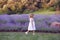 little girl in a dress plays and walks in a lavender field