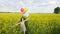 Little girl in a dress running through yellow wheat field with balloons in hand. slow motions