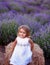 little girl in a dress sits on a manger in a lavender field