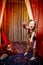 Little girl dressed in a costume with ears and tail poses in stylized theatrical circus photo shoot with a toy tiger