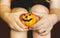 A little girl dressed in a witch costume for Halloween holds a pumpkin lantern in her hands close-up. A Child Holds Jack`s Pumpkin