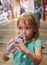 Little girl drinks water from a large bottle.
