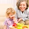 Little girl eat apricot fruit with grandmother