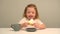 Little girl eating a cake at the kitchen table