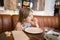 Little girl eating croquette with hand in restaurant