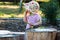 Little girl eating fresh bio green peas in sunlit rural garden