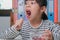 Little girl eating fresh red grapes at home in the living room. Cute young Asian girl eats healthy fruits and milk for her meal.