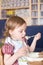 Little girl eating porridge at home