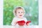 Little girl eating raspberry in white dining room