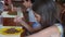 The little girl eats buckwheat noodles with a fork reluctantly. The child refuses to eat. Slow-motion shooting.