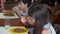 The little girl eats buckwheat noodles with a fork reluctantly. The child refuses to eat. Slow-motion shooting.