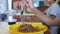 The little girl eats buckwheat noodles with a fork reluctantly. The child refuses to eat. Slow-motion shooting.