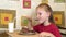 Little girl eats cake using a spoon. A happy child loves sweetness.