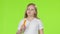 Little girl eats a carrot and shows a thumbs up. Green screen