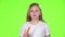 Little girl eats a carrot and shows a thumbs up. Green screen. Slow motion
