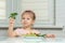 Little girl eats vegetables