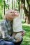 Little girl embraces grandfather, sits on arms and